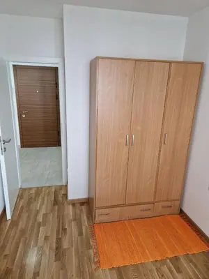 a large wooden cabinet in a room with a door at Ada flat in Banja Luka