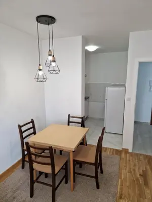 a dining room with a wooden table and chairs at Ada flat in Banja Luka