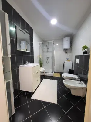 a bathroom with two sinks and a shower and two toilets at KRUNA Apartment in Cazin