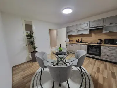 a kitchen with a table and chairs in a room at KRUNA Apartment in Cazin