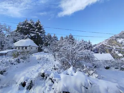 a yard covered in snow with a house in the background at Old Town in Livno