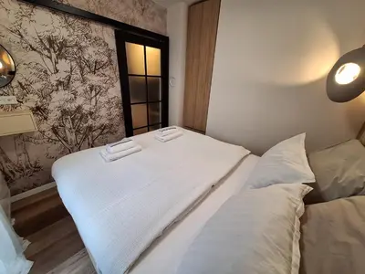 a white bed in a room with a window at Urban Cube Apartment - Tuzla City Center in Tuzla