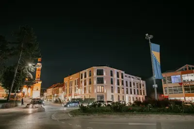 a building on a city street at night at Urban Cube Apartment - Tuzla City Center in Tuzla