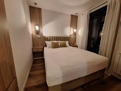 a bedroom with a large white bed and two lamps at Urban Cube Apartment - Tuzla City Center in Tuzla