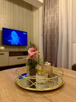 a table with a glass tray with a flower on it at Alexa Apartmani in Banja Luka
