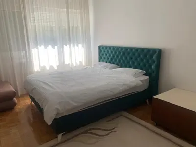 a bed with a blue headboard in a bedroom at Slobo- stan na dan in Banja Luka