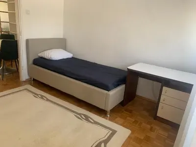 a small bedroom with a bed and a desk at Slobo- stan na dan in Banja Luka