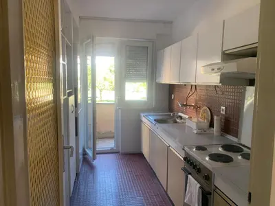 a kitchen with white cabinets and a stove top oven at Slobo- stan na dan in Banja Luka