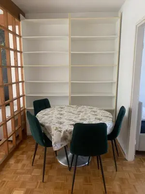 a table and chairs in a room with shelves at Slobo- stan na dan in Banja Luka