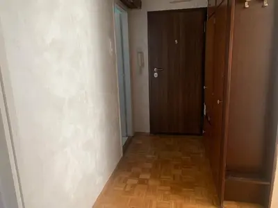an empty hallway with a door and a wooden floor at Slobo- stan na dan in Banja Luka