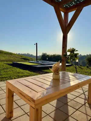 a wooden picnic table on a patio with a roof at Harmony cottage in Banja Luka