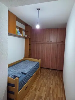 a small bedroom with a bed and wooden cabinets at Apartment SOFI Novi Travnik in Novi Travnik