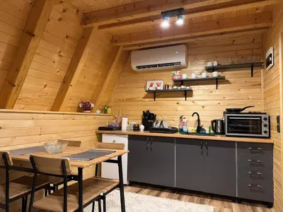 a kitchen with wooden walls and a table and chairs at Soul Rest in Visoko