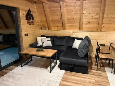 a living room with a black couch and a table at Soul Rest in Visoko