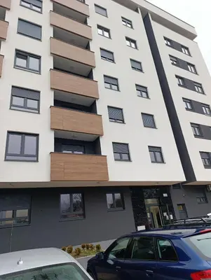 a large white building with wooden fronts at Apartman Home Away in Banja Luka