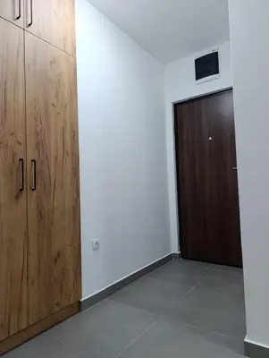 an empty room with wooden cabinets and a door at Apartman Home Away in Banja Luka