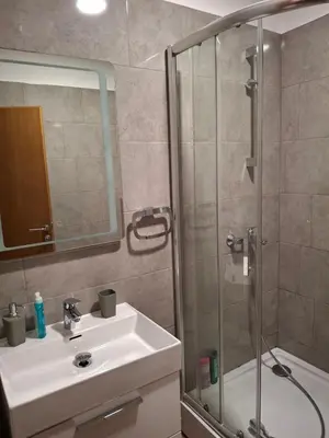 a bathroom with a shower and a sink and a mirror at Koncept RK in Banja Luka