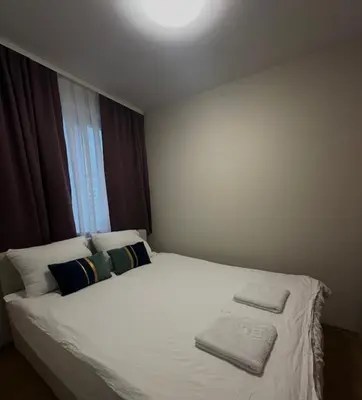 a white bed in a room with a window at Apartman ARENA 2 Doboj in Doboj