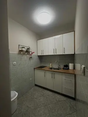 a kitchen with white cabinets and a counter top at Apartman ARENA 2 Doboj in Doboj