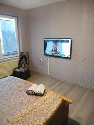 a bedroom with a bed and a flat screen tv at KONAK kod ODISEJE 3 in Tuzla
