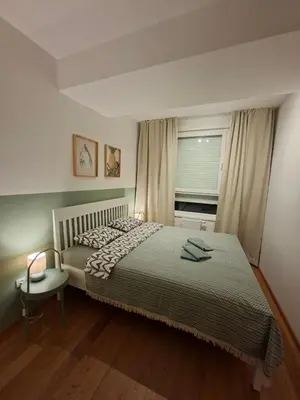 a bedroom with a bed and a window and a chair at Olive NOOK in Banja Luka
