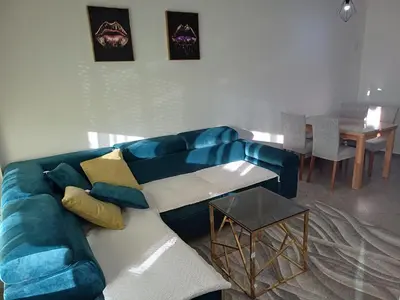 a blue couch in a living room with a table at Apartman Kratos in Banja Luka