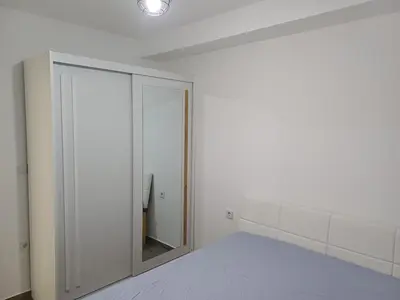 a white room with a bed and a mirror at Apartman Kratos in Banja Luka
