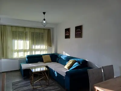 a living room with a blue couch and a table at Apartman Kratos in Banja Luka