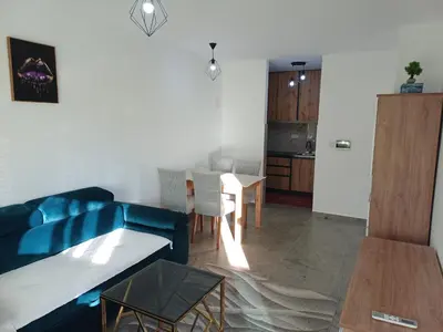 a living room with a blue couch and a table at Apartman Kratos in Banja Luka