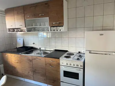 a kitchen with a stove and a white refrigerator at Apartman Zvjezdica in Banja Luka
