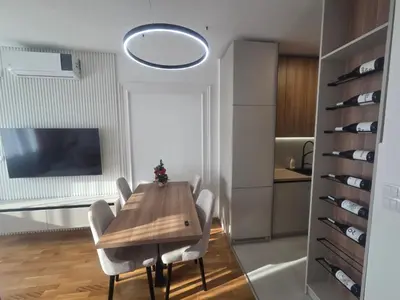 a dining room with a wooden table and chairs at Apartman Damjan in Banja Luka
