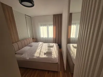 a bedroom with a bed and a mirror at Apartman Damjan in Banja Luka