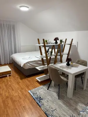 a bedroom with a bed and a table and chairs at Papa Glisa in Banja Luka