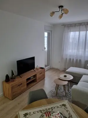 a living room with a flat screen tv and a couch at Apartman Mila in Doboj