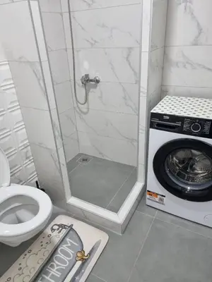 a bathroom with a toilet and a washing machine at Apartman Mila in Doboj