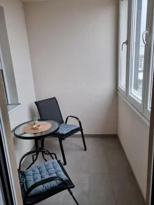 a small table and chair in a room with a window at Apartman Mila in Doboj