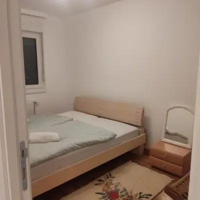 a small bedroom with a bed and a mirror at Ella apartman in Banja Luka