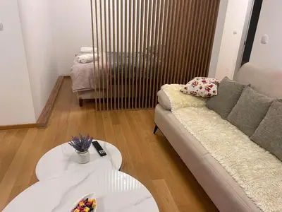 a living room with a couch and two tables at Taša 1 in Banja Luka