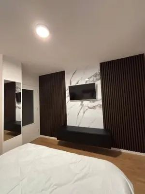 a bedroom with a bed and a flat screen tv at Apartman S52 in Doboj