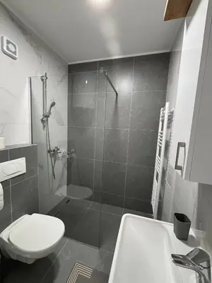 a bathroom with a shower and a toilet and a sink at Apartman S52 in Doboj