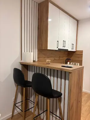 a kitchen with two black chairs at a counter at Apartman S52 in Doboj