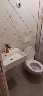 a bathroom with a white toilet and a sink at Apartman Ani in Hiseti