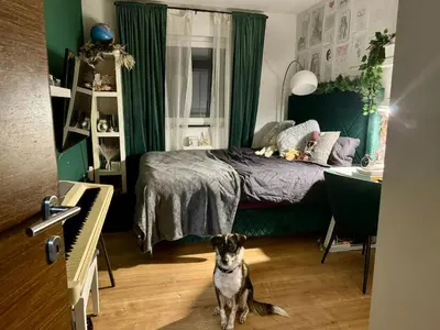 a dog sitting in front of a bed in a bedroom at Luxe Residence Home Sweet Home City Center in Banja Luka