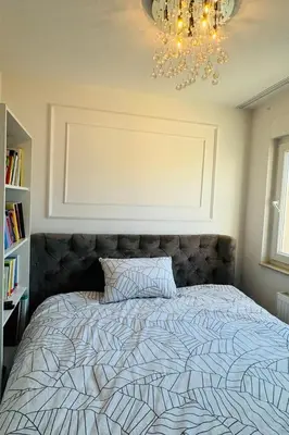 a bed in a bedroom with a chandelier at Luxe Residence Home Sweet Home City Center in Banja Luka