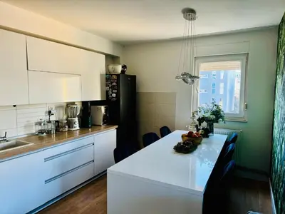 a kitchen with a white table and a black refrigerator at Luxe Residence Home Sweet Home City Center in Banja Luka