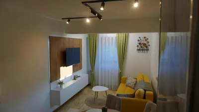 a living room with a yellow couch and a tv at Apartmani Flocke Vlašić in Šišava
