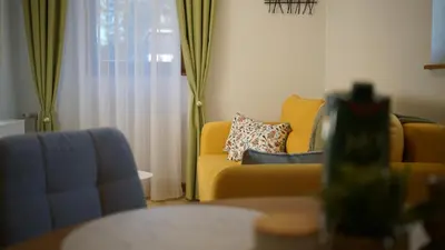 a living room with a yellow couch and a window at Apartmani Flocke Vlašić in Šišava