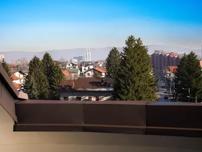 a view of a city from a balcony with trees at PENTHOUSE ROYA BiHAC in Bihać