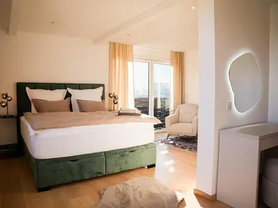 a bedroom with a large bed with a large window at PENTHOUSE ROYA BiHAC in Bihać
