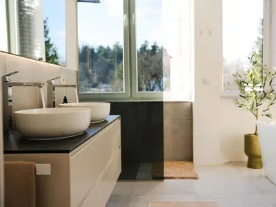 a bathroom with two sinks on a counter with windows at PENTHOUSE ROYA BiHAC in Bihać